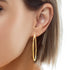 Close-up of a woman's ear featuring a Big 5.4 cm Hoops Earring, made of 14k gold-filled material and measuring 2 mm thick. Her short, straight hair perfectly complements the statement piece against a white background, accentuating the earring's luster.